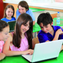 Schoolchildren having fun on laptops at  classroom.